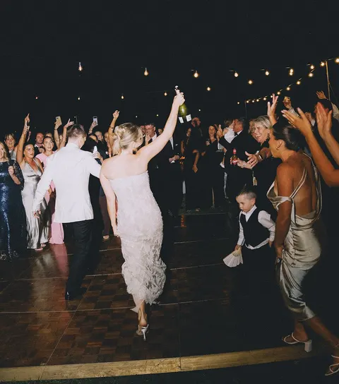 A couple dancing in the middle of their guests on the dance floor