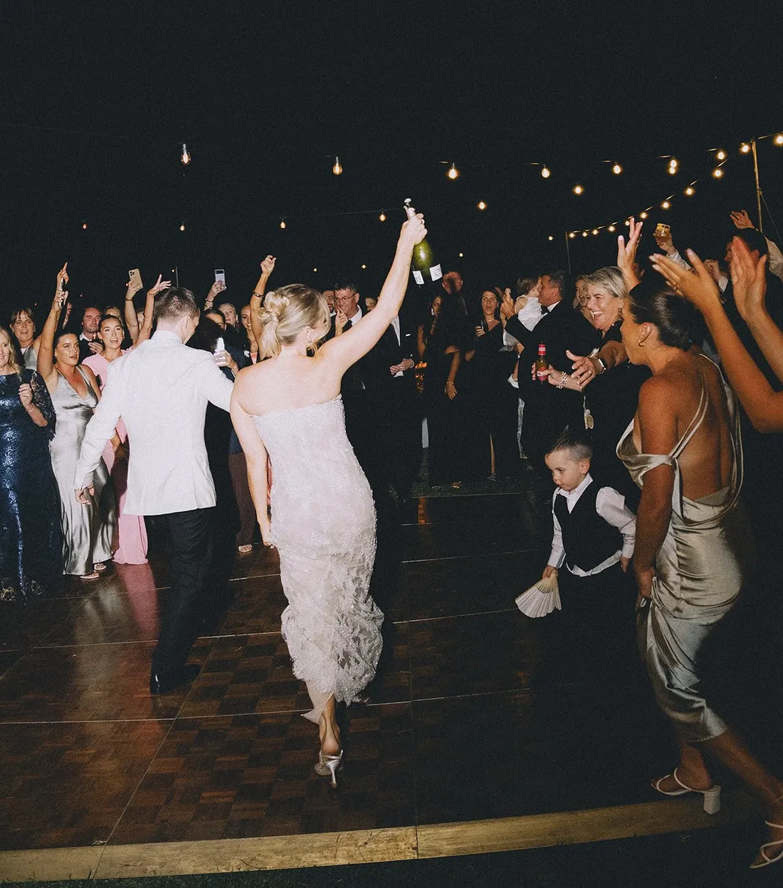 Newlyweds celebrating on the dance floor under festoon lights at Maroon Hill Estate