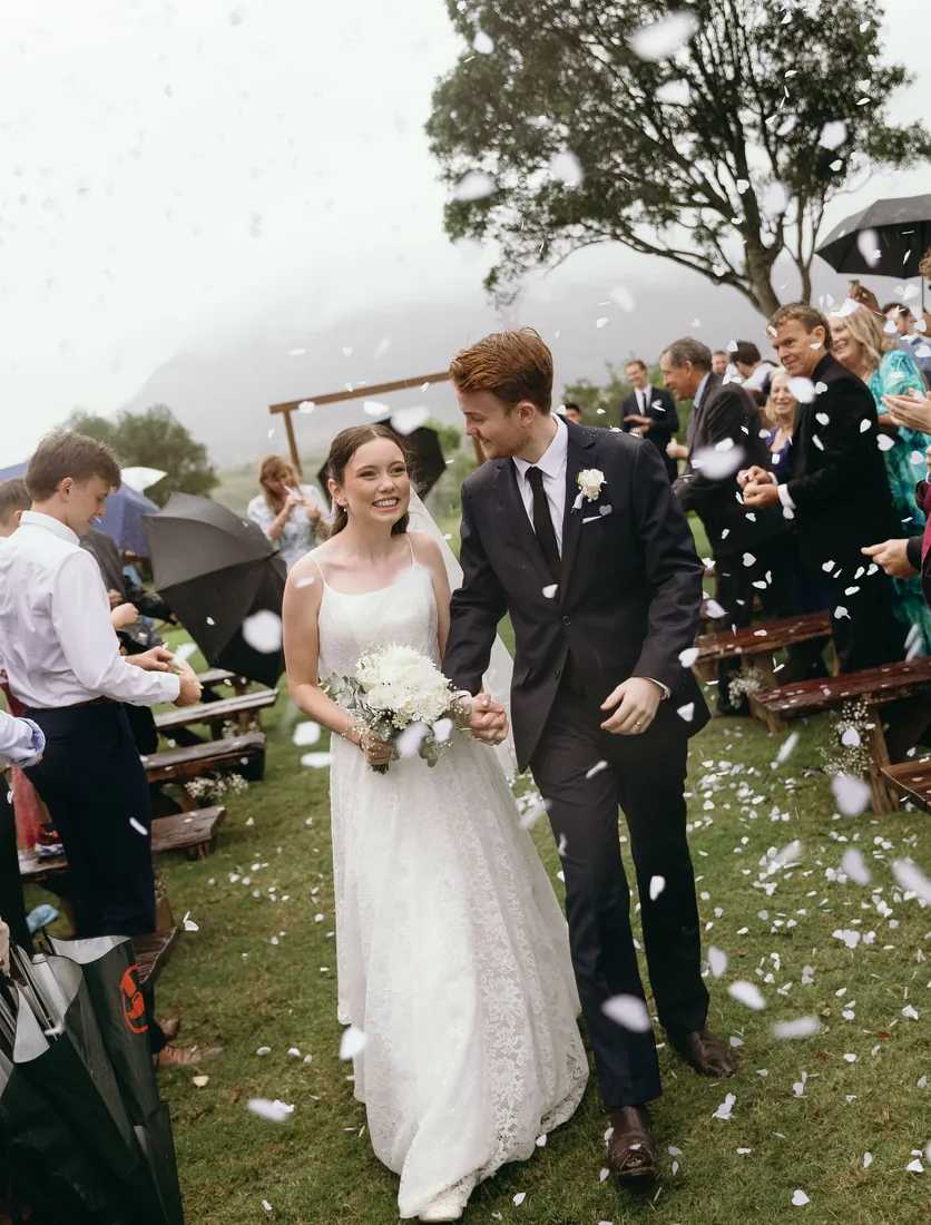 Daniel and Emily walking through confetti at Maroon Hill Estate