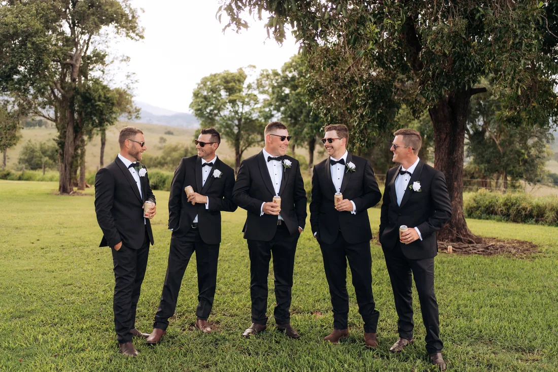 Groomsmen laughing together on the lawn before the ceremony