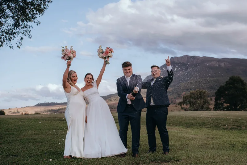 Bridal party celebrating with champagne on the lawn at Maroon Hill Estate