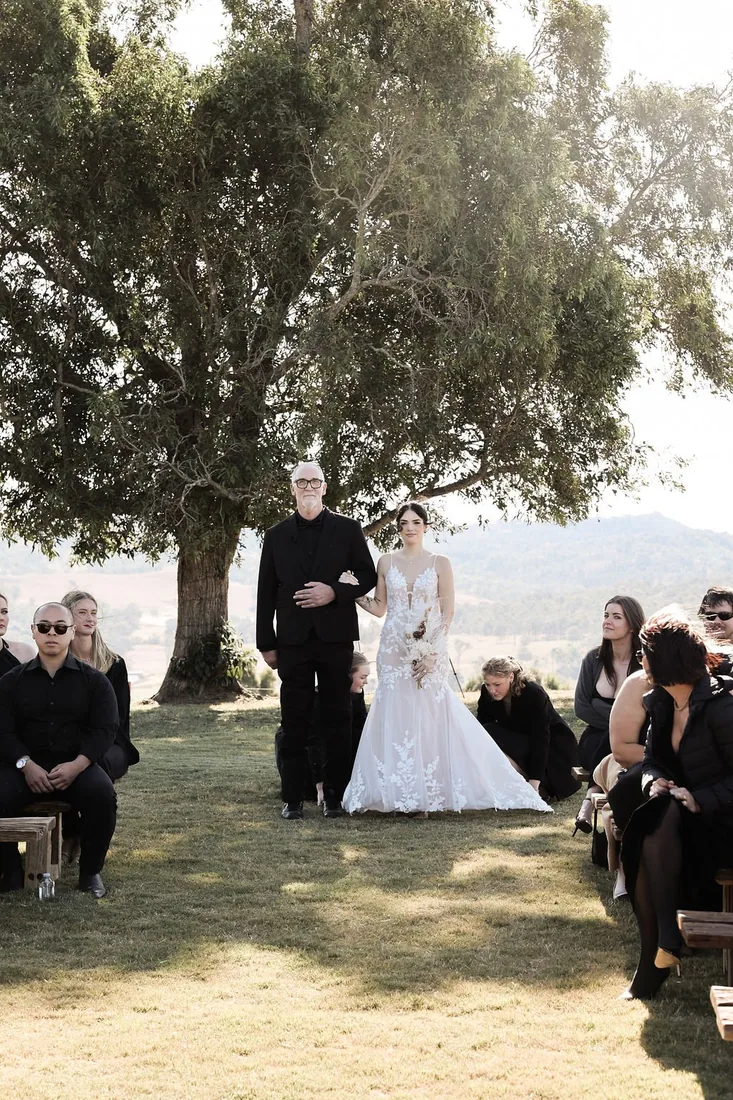 Kate and Jacob's black tie wedding party under a tree at Maroon Hill Estate