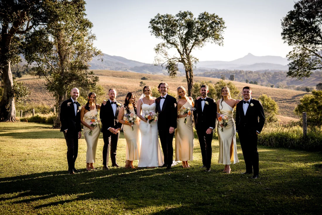 Full bridal party group photo in cream and black, golden hour, mountain backdrop
