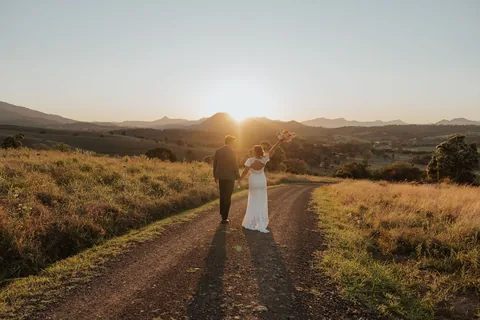 A couple walking down the drive into the setting sun