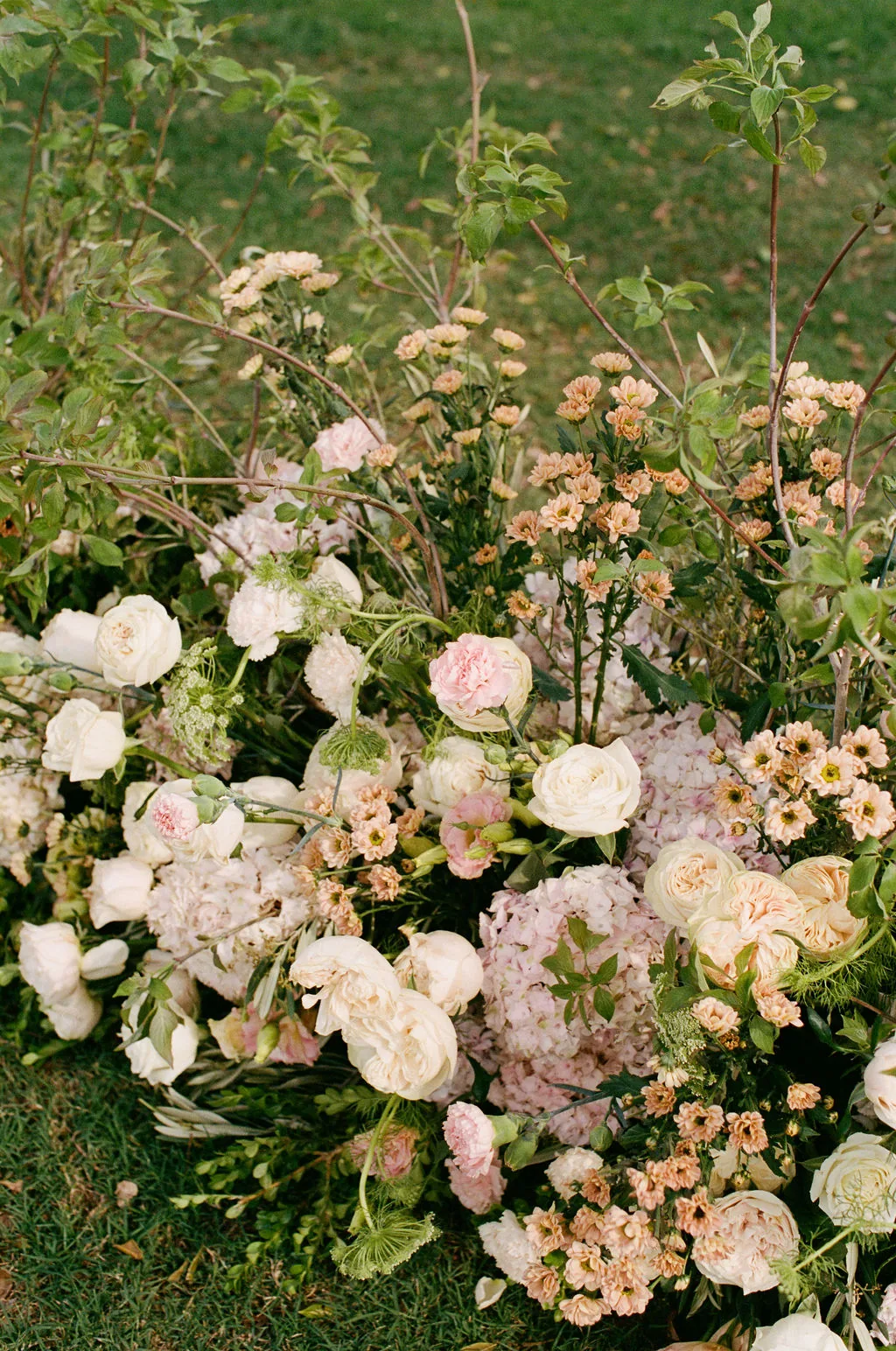 Close-up of a lush ivory and blush floral arrangement with garden roses and hydrangea