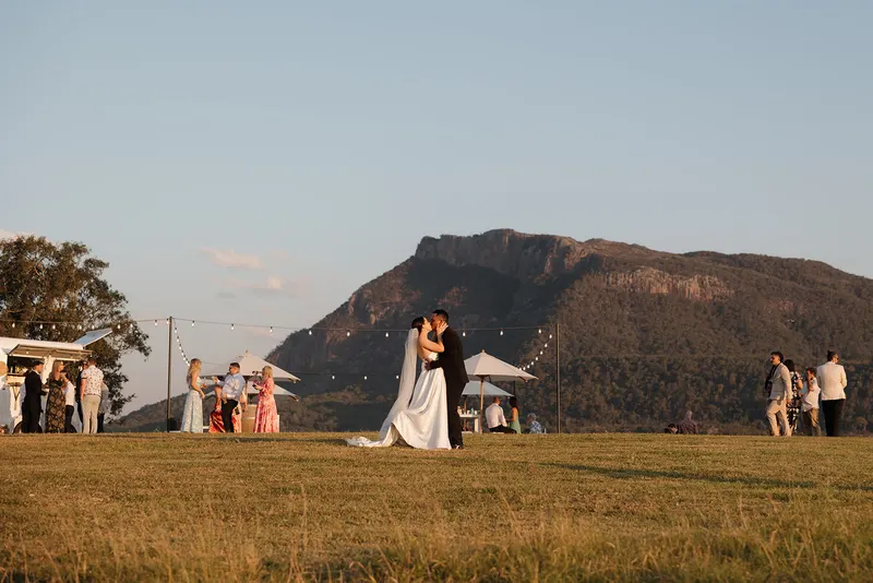 A couple on the open lawn with Mount Maroon rising behind them