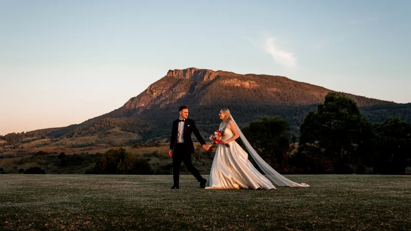 Gabi and Alec walking the lawn at dusk with Mount Maroon behind them