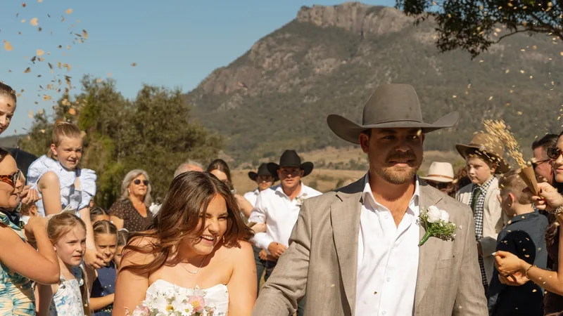 Maddy and Jace leaving their ceremony through confetti, Mount Maroon behind them